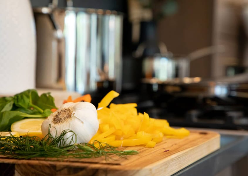 Garlic and bell peppers on a cutting board.