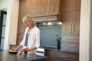 Older woman opened a meal in a plastic container.