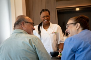 Senior couple chatting while the personal chef prepares meals.