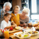 Happy senior couple preparing food with young grandchildren